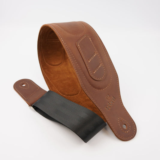 A brown leather guitar strap with a black webbing, displayed on a clean white background.