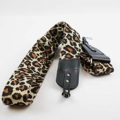 A leopard print camera strap with black leather accents and silver hardware, laid out on a white background.
