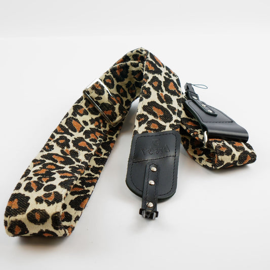 A leopard print camera strap with black leather accents and silver hardware, laid out on a white background.