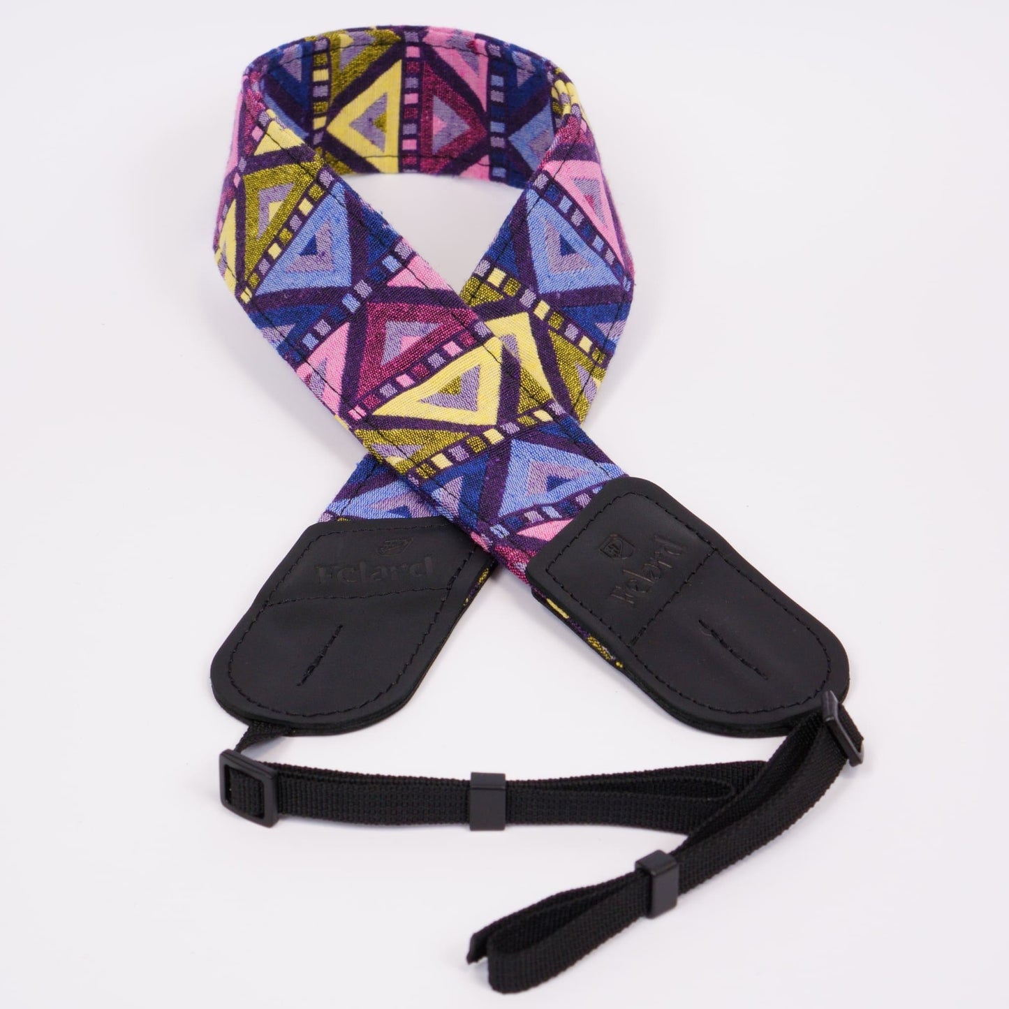 A camera strap featuring a vibrant geometric pattern in pink, purple, blue, and yellow, with black plastic buckles and a black adjustable webbing strap, shown on a plain white background.