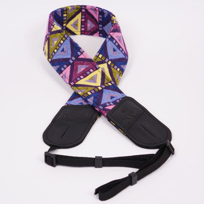 A camera strap featuring a vibrant geometric pattern in pink, purple, blue, and yellow, with black plastic buckles and a black adjustable webbing strap, shown on a plain white background.