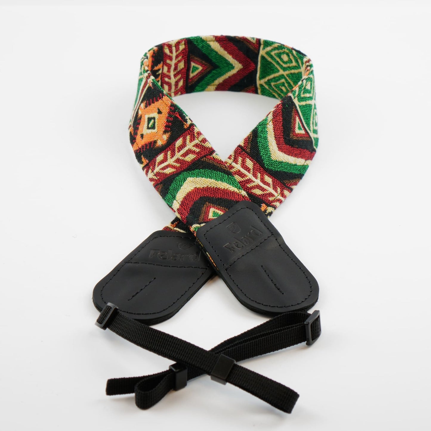 A camera strap featuring a colorful geometric pattern in green, red, orange, and beige, with black padded leather ends and adjustable black webbing.
