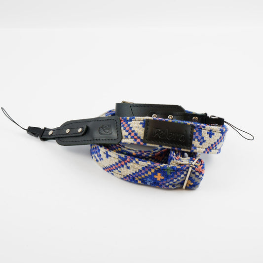A Felard brand camera strap featuring a blue, red, and beige geometric patterned woven fabric with black leather accents and silver metal hardware, displayed on a clean white background.