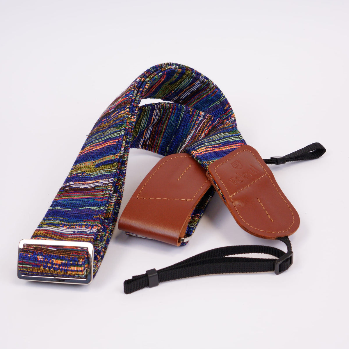 A multicolor camera strap with brown leather ends and black adjustment straps, displayed on a clean white background.