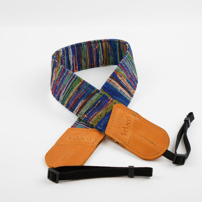 A multicolor striped camera strap with tan leather end caps and black adjustable webbing, shown on a clean white background.