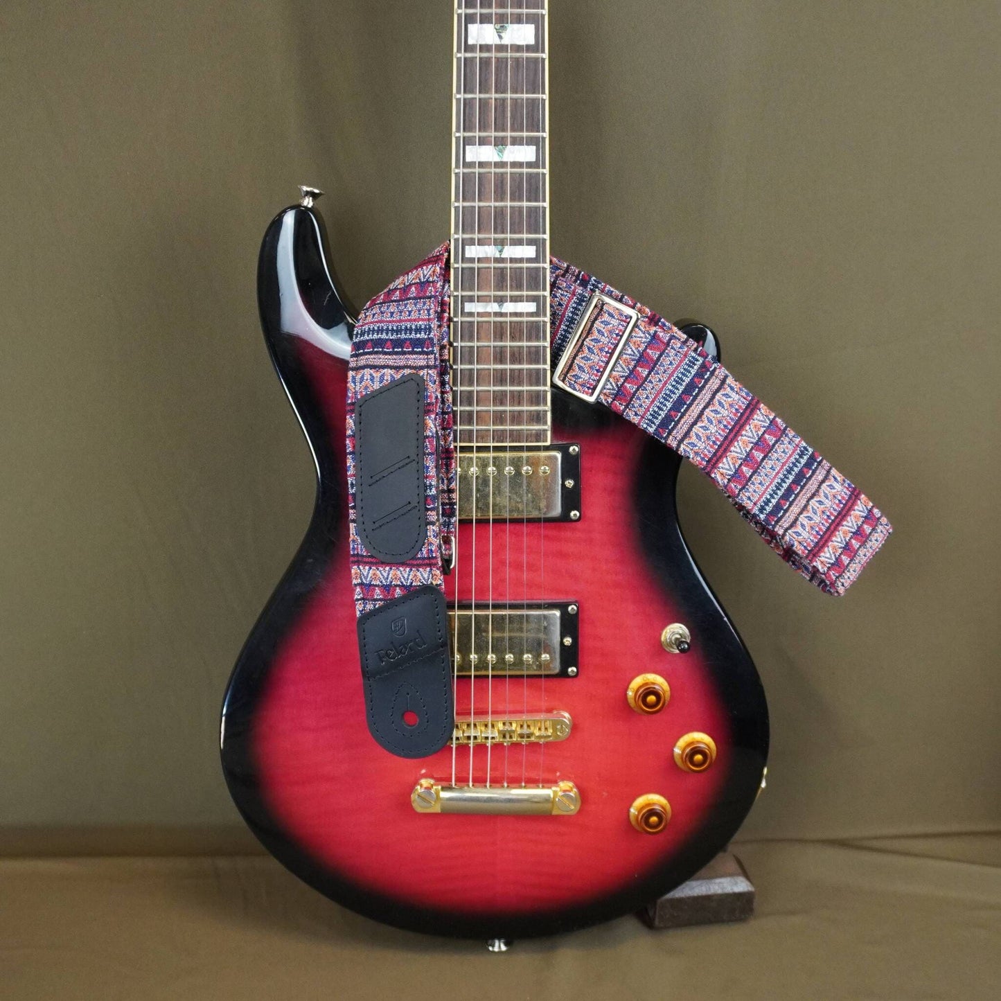  colorful patterned strap, displayed against a solid brown background.