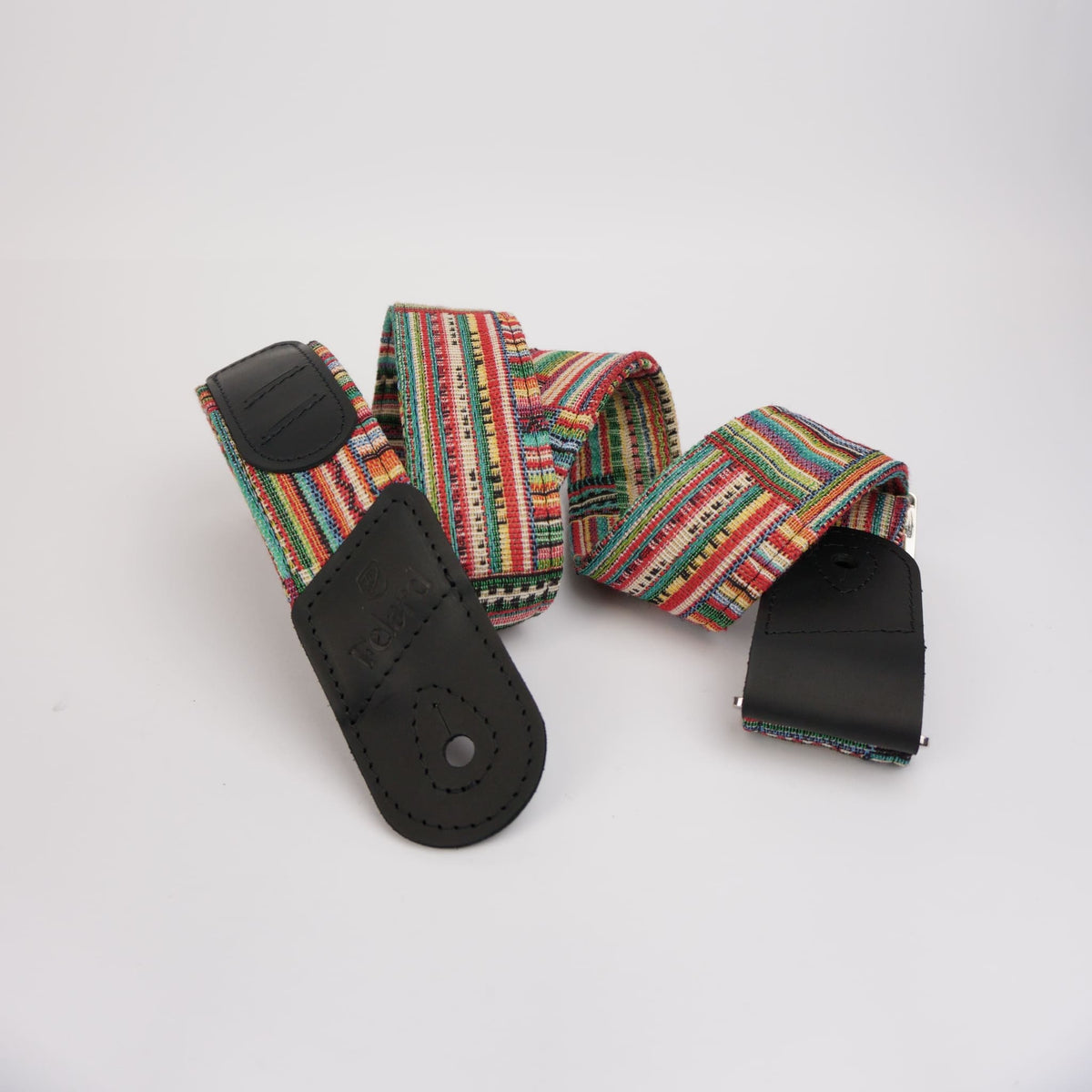 A woven guitar strap with a vibrant multicolor pattern of red, green, yellow, and blue stripes, featuring black leather ends displayed on a clean white background.