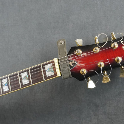 A close-up of a guitar headstock adapter from gray matte leather