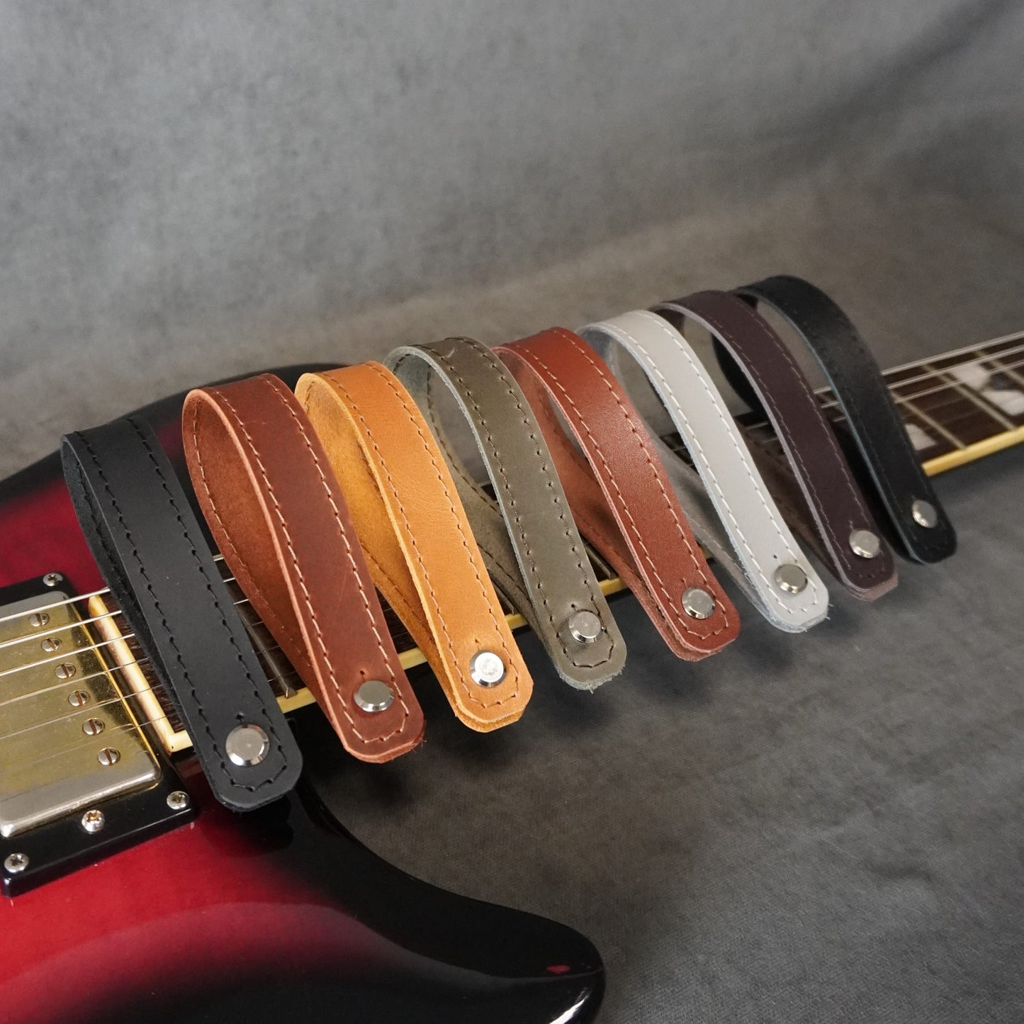 Handmade guitar headstock adapters with vintage matte and smooth glossy leather finishes