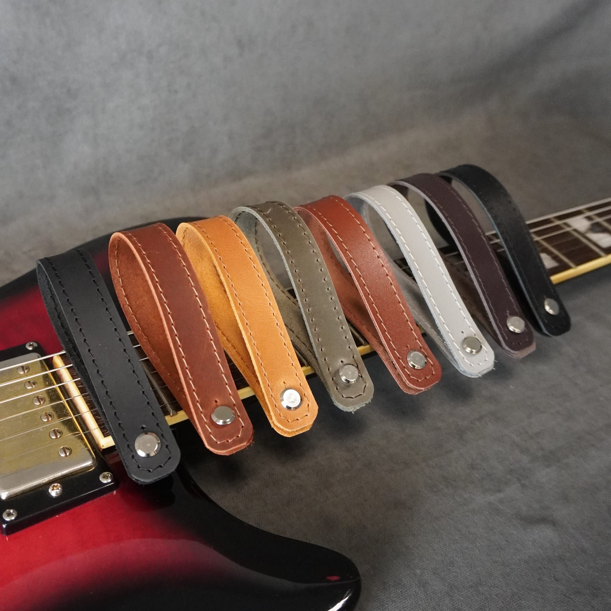 Handmade guitar headstock adapters with vintage matte and smooth glossy leather finishes