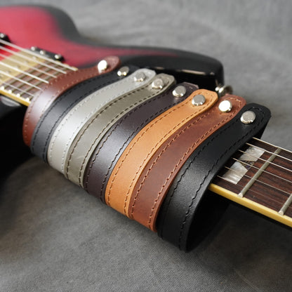 Handmade leather guitar strap adapters available in matte and smooth leather finishes on the guitar