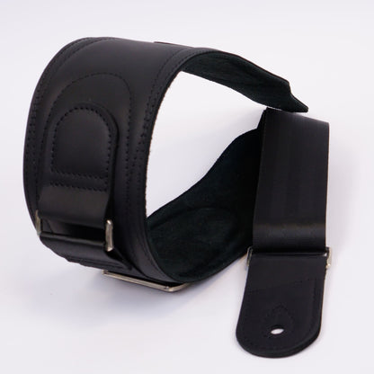 A black leather shoulder guitar strap with adjustable metal buckles, shown on a plain white background.