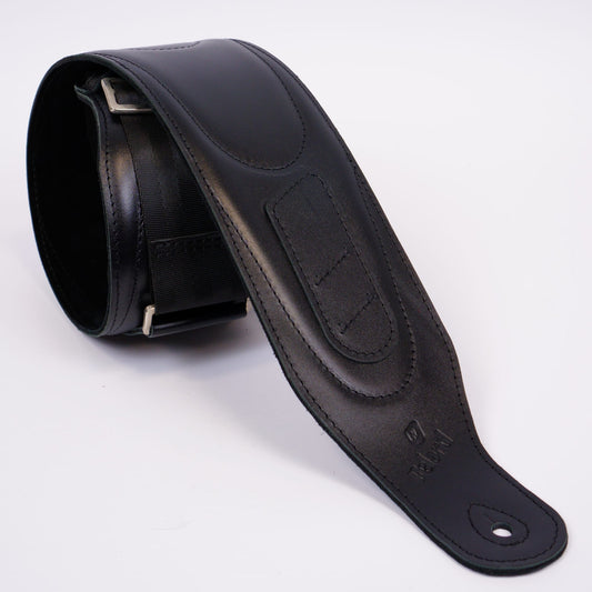 A black leather guitar strap with silver metal buckle, shown coiled on a white background.