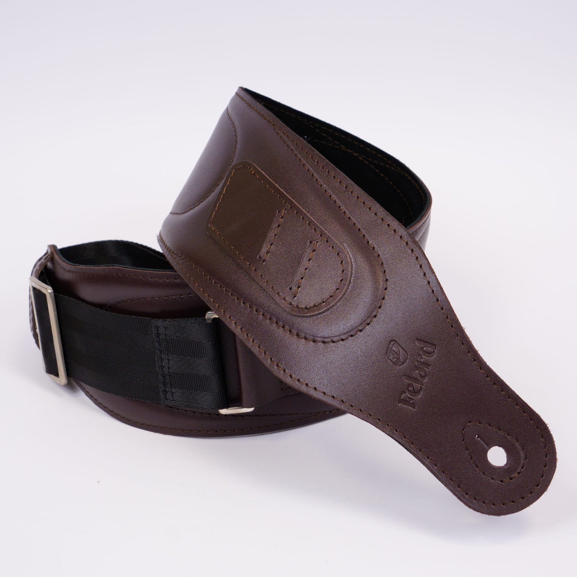 A dark brown leather guitar strap with a black webbing loop and silver buckle, coiled on a white background. The brand name 'Felard' is embossed on the leather.