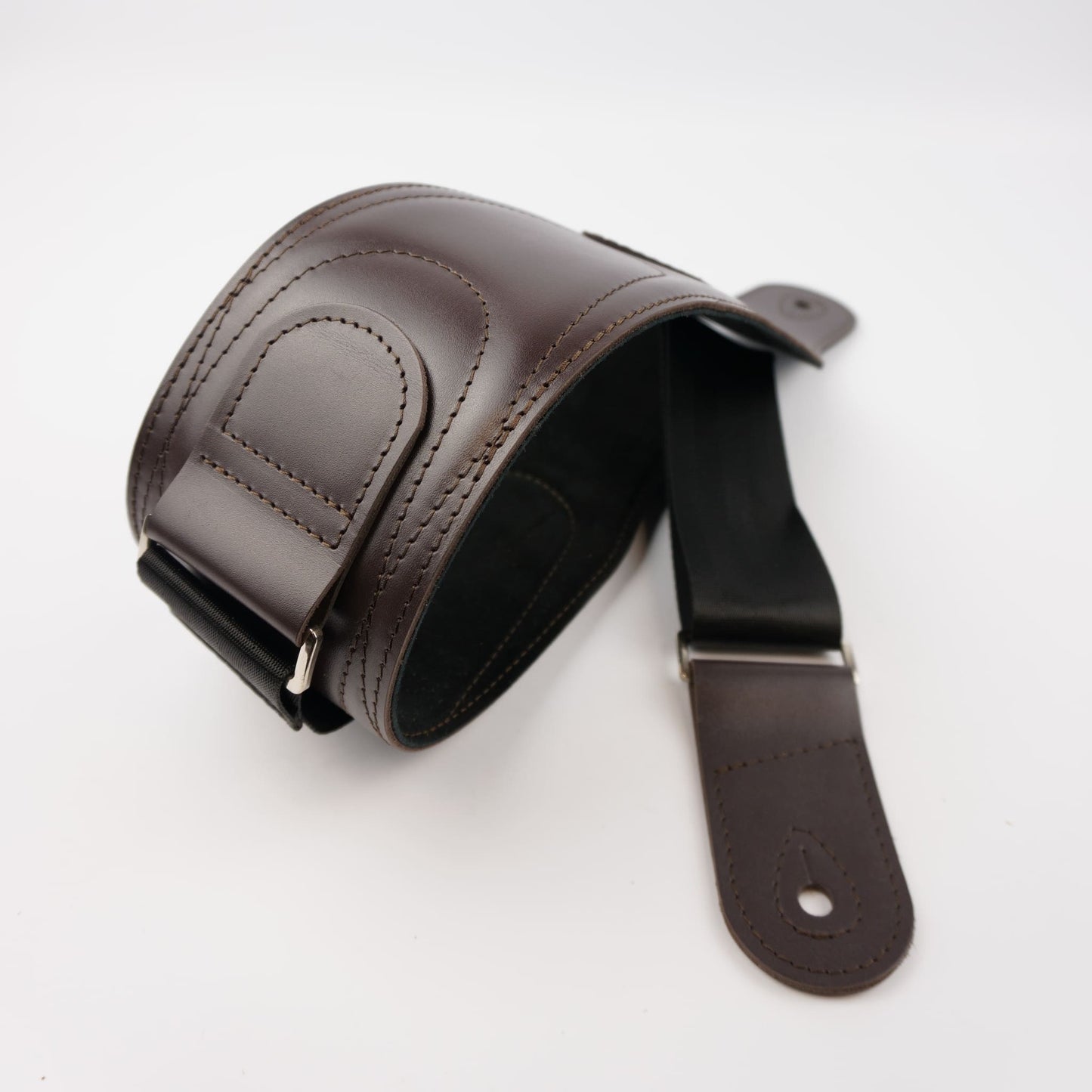 A dark brown leather guitar strap with a matching adjustable buckle, displayed on a clean white background.