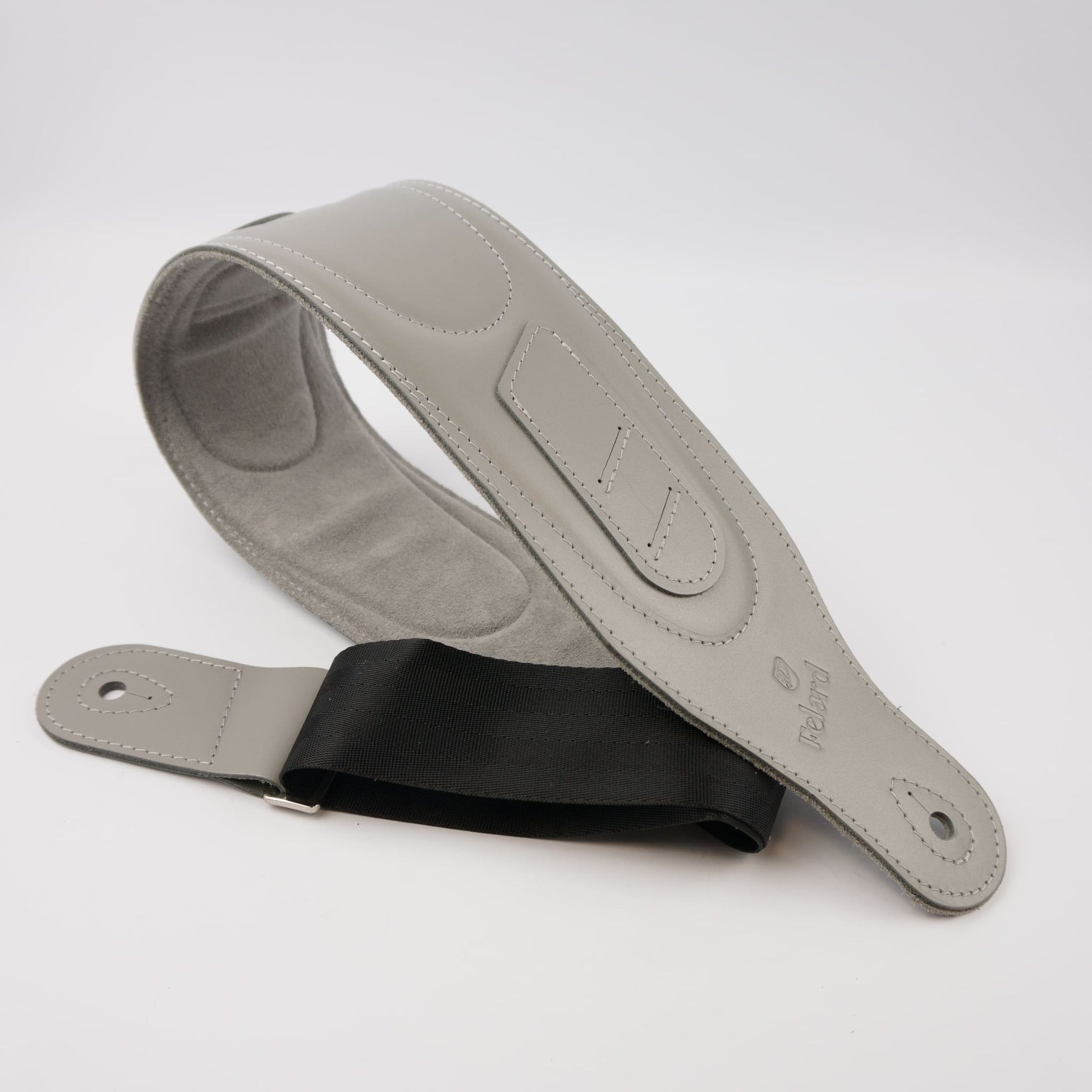 A light gray guitar strap with a black adjustable webbing , shown on a clean white background.